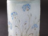 un vase blanc orné de fleurs bleues