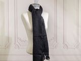 a black scarf hanging on a mannequin in a room