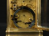 a gold clock with a glass case on a black background