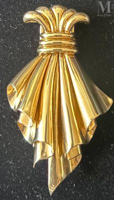a gold brooch on a black surface