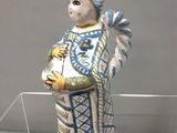 une figurine représentant une femme vêtue d'une robe bleue et blanche