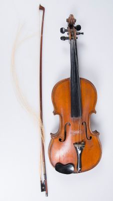 un violon et un archet posés sur une surface blanche