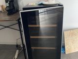 a black and silver wine cooler sitting on the floor
