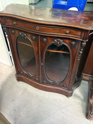 une armoire en bois avec un plateau en marbre et une porte vitrée