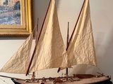 une maquette de voilier exposée devant un tableau