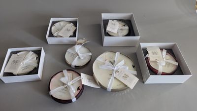 six white boxes with different types of candles in them sitting on a table