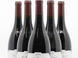 quatre bouteilles de vin sont alignées sur une surface blanche