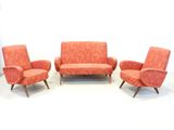 three chairs and a couch in a room with a white wall