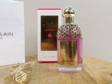 the bottle of perfume is next to the box on the table