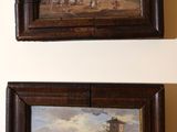 deux tableaux encadrés accrochés au mur d'une pièce où se trouve déjà un tableau accroché au mur