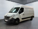 La camionnette blanche est garée dans une grande pièce au sol gris.