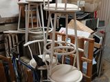 a lot of chairs and stools stacked on top of each other