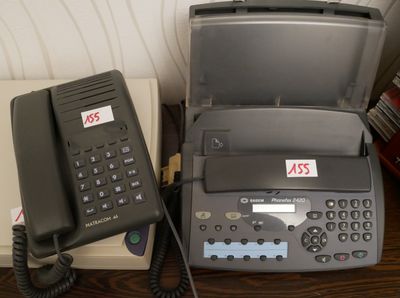 un téléphone et une imprimante posés l'un à côté de l'autre sur un bureau