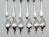six silver spoons are arranged in a row on a white surface