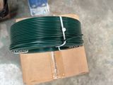 a roll of green wire sitting on top of a cardboard box