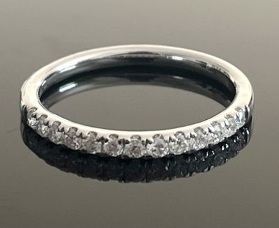 une image d'une bague en diamant sur une surface réfléchissante