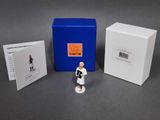 une petite figurine devant une boîte bleue