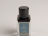 a bottle of perfume sitting on a white surface