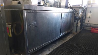 a stainless steel cabinet in the middle of a kitchen