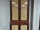 a tall wooden cabinet with two doors on it