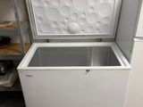 a white chest freezer sitting in the corner of a room