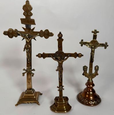 trois crucifix en laiton vieilli sur fond blanc