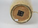 a brown vase with a tag on it on a white surface