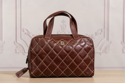 a brown handbag sitting on top of a wooden table