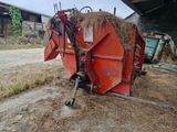 un tracteur garé à côté d'un tas de foin