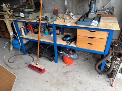 a blue workbench with tools on it in a garage