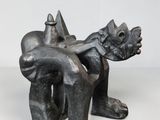 un gros plan sur une sculpture représentant une personne assise sur une chaise