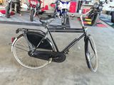 a black bicycle parked in a garage with other motorcycles