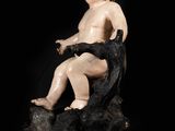 a small statue of a boy sitting on a tree stump