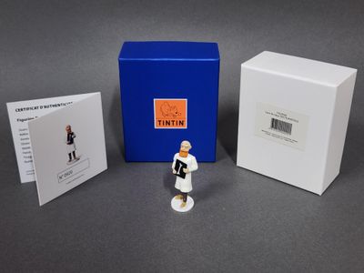 une petite figurine devant une boîte bleue