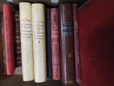 several old books are lined up on a shelf in a library