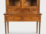 un vieux bureau en bois muni de deux tiroirs et d'une porte vitrée