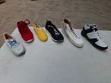 Plusieurs paires de chaussures de tennis sont alignées sur une table