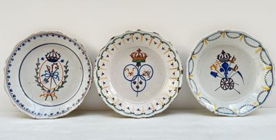 trois assiettes à motifs posées sur une surface blanche