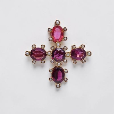 un gros plan d'une croix composée de pierres roses