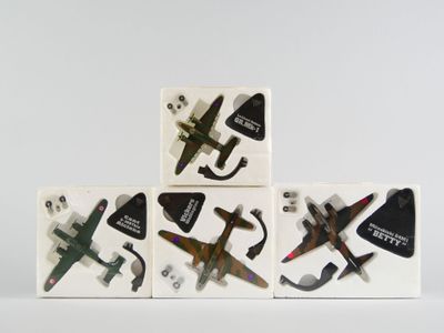 Plusieurs petits avions sont posés les uns sur les autres sur une surface blanche.