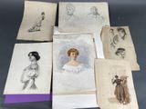 Plusieurs dessins représentant des femmes en robe et avec un chapeau sont posés sur une table