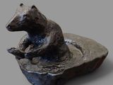 une statue représentant un ours assis sur un rocher