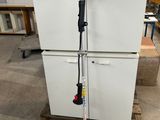 a picture of a red and black corded string trimmer on a wooden pallet