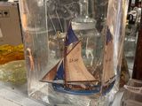 a glass box with a boat inside of it on a shelf