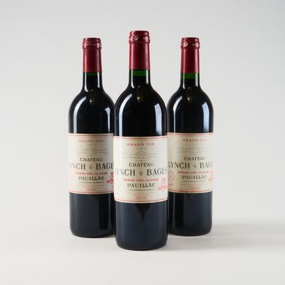three bottles of red wine sitting on top of a white table