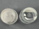 two clear glass bowls with lids on a black surface