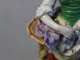 a figurine of a woman holding a basket of flowers