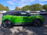 a green suv parked in a parking lot with other cars in the background