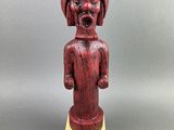 une statue en bois d'un homme avec un chapeau sur la tête