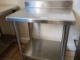 a stainless steel work table in a kitchen with a sink